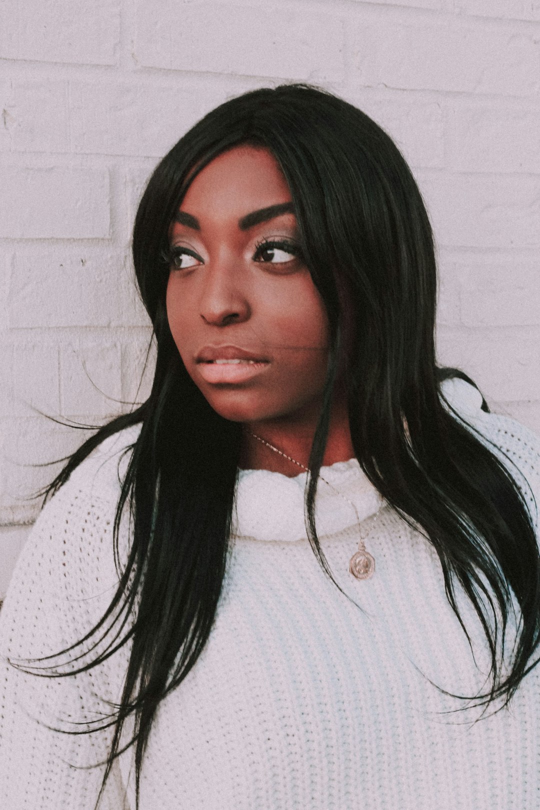 Photo by Liz Weddon smiling woman leaning standing near white wall